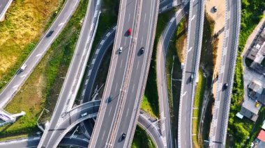 Arabalar Avrupa yollarında zikzak çiziyor. Avrupa 'nın dolambaçlı yollarının hava görüntüsü, yeşillik ortasındaki karmaşık ağda gezinen arabalar..