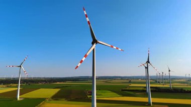 AB rüzgar türbinleri temiz enerji üretir. Rüzgâr türbinleri uçsuz bucaksız bir arazide döner, açık mavi gökyüzünün altında güçlü rüzgarlardan gelen enerjiyi kullanırlar..