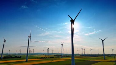 Rüzgar türbinleri yeşil enerji üretir. Rüzgar türbinleri parlak bir gökyüzüne karşı yükselir, geniş bir Avrupa arazisinde yenilenebilir enerji yakalar..