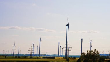 Rüzgar türbinleri temiz enerji üretir. Rüzgâr türbinleri temiz bir kırsal gökyüzünde yükseliyor, rüzgar enerjisinden faydalanıyor ve sürdürülebilir teknoloji sergiliyor..