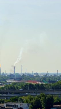 Duman endüstri üzerinde yükseliyor. Fabrika bacaları açık bir günde genişleyen sanayi bölgesinin üzerine salınımlar salıyor..