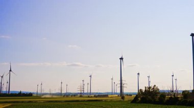 Geniş alanlarda rüzgar türbinleri ve güç iletim kuleleri. Yeşil enerji üretimi kavramı.