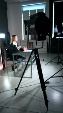 Masada oturan kadına Soffit yönlendirdi. Bir program ya da blogun stüdyo görüntüleri. Dikey video.