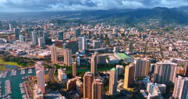 Modern Honolulu 'nun güzel manzarası, Oahu, Hawaii, ABD. Yeşil dağlar arka planda dramatik bulutlarla kaplıdır..