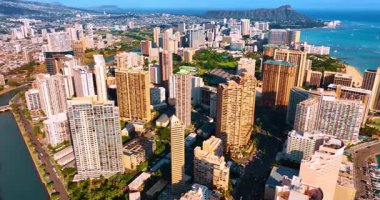 Modern Waikiki, Honolulu, Hawaii, ABD 'nin yüksek binalarına yaklaşıyoruz. Arkaplanda mavi okyanusla çevrili Diamond Head Krateri. Hava görünümü.