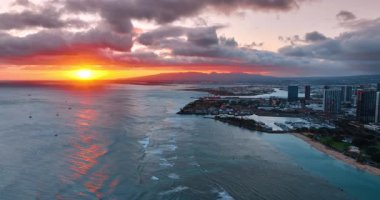 Pasifik Okyanusu 'nun üzerindeki gri bulutlarla kaplı güneş batıyor. Gün batımında Honolulu, Hawaii, ABD sahilinde uçuş.