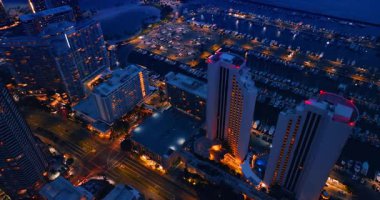 Binalar, sokaklar ve yatlar alacakaranlıkta güzelce aydınlatılır. İHA görüntüleri lüks Waikiki, Hawaii, ABD 'de yükseliyor..