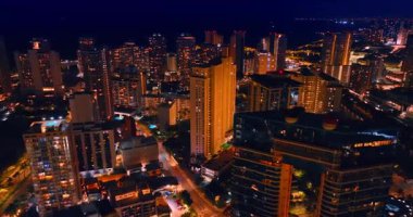 Yüksek mimarisi olan güzel bir şehrin şehir manzarası. Gece vakti Hawaii, ABD 'de fantastik bir şekilde aydınlatılmış Waikiki' ye hava perspektifi.