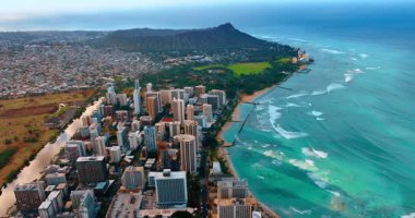 Dalgalar Waikiki, Honolulu, Hawaii, ABD sahillerine doğru akar. Şehir manzarası ve elmas başlıklı krater üzerine hava perspektifi.