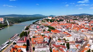 Bratislava nehrinin havadan görünüşü. Avrupa 'da güneşli bir günde, canlı çatılar ve tarihi binalar Bratislava' daki Tuna Nehri 'ni kaplar..