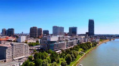 Bratislava ufuk çizgisinde nehir manzarası var. Bratislava, açık ve güneşli bir günde Tuna Nehri boyunca çağdaş mimariyi ön plana çıkaran canlı bir ufuk çizgisi sergiliyor.