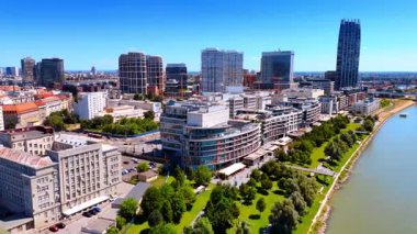 Tuna Nehri 'nin kıyısındaki güzel yeşil parkın üzerinde uçuyor. Bratislava, Slovakya 'nın güneşli şehir manzarasına hava perspektifi.