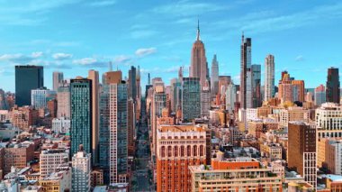 Metropolün yoğun inşa edilmiş kentsel alanından geçen uzun düz bir cadde. Manhattan, New York 'un gökdelenleri.