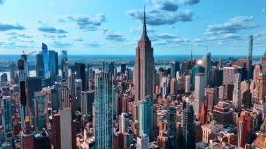 Manhattan, New York 'taki muhteşem Empire State Binası' ndan uzakta. Metropolis 'in muhteşem manzarası mavi gökyüzünün arka planında kabarık bulutlarla.