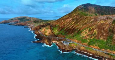 Pasifik Okyanusu 'nun kayalık kıyısını geçen yola bakın. Oahu 'daki volkanik dağlar, Hawaii, ABD. Hava perspektifi.
