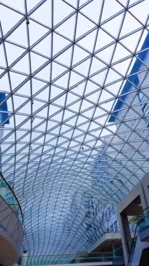 Modern mimari cam çatı tasarımı. Çarpıcı cam tavan yapısı, şehir merkezinde bir alışveriş alanının üzerinde geometrik desenler sergiliyor..