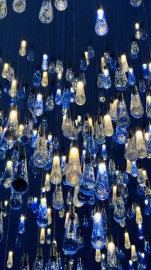 Göz kamaştırıcı cam lambalar. Cam aydınlatma armatürlerinin çarpıcı bir düzeni karanlık bir ortamda çarpıcı bir görsel etki yaratır..