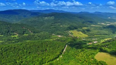 Bereketli yeşil dağ manzarası. Bereketli yeşil dağlar ufuk boyunca uzanır berrak mavi bir gökyüzünün altında, gündüz vakti doğanın güzelliğini gösterir..