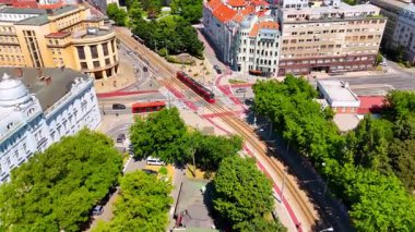 Bratislava, Slovakya şehir merkezindeki tramvayı takip ediyoruz. Güneşli şehir manzarasında İHA görüntüleri.