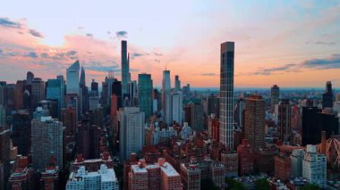 Gün batımında pembe gökyüzünün arkaplanındaki Manhattan manzarası. New York, ABD 'deki Queensboro Köprüsü' ne yaklaşıyoruz..