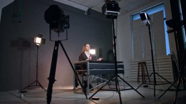 Masada oturan ve konuşan kadına yönelikti. Stüdyodaki kendine güvenen bayan kayıt blogunda düşük açılı görüş.