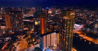 Gece tatil köyünün yollarında hareketli bir trafik var. Modern Waikiki, Honolulu, Hawaii, ABD 'nin göz kamaştırıcı aydınlığı. Hava görünümü.