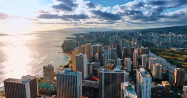 Güzel Waikiki şehri, Honolulu, Hawaii, ABD. Parlak güneş okyanusun su manzarasına yansıyor. Gri bulutlar gökyüzünü kaplıyor. Hava görünümü.