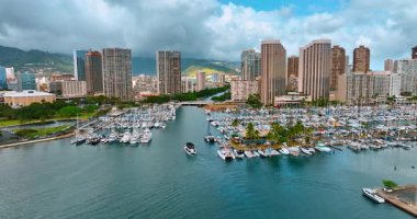 Honolulu, Hawaii, ABD sahilindeki büyük yat kulübünden uçuyor. Arkaplanda ufku kaplayan kalın gri bulutlu manzara.