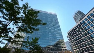 Şehirdeki ya da şehirdeki modern binaların dışındakiler. Mavi gökyüzünün arkaplanındaki mimari tasarımda alçak açı görünümü.