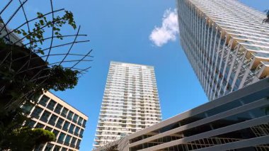 Exteriors of the modern buildings in the town or city. Low angle view at the architecture design at the backdrop of blue sky.