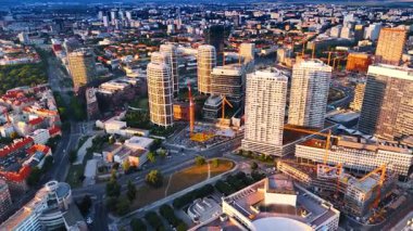 Parlak güneş gökdelenlerin cephelerine yansıyor. Slovakya, Bratislava 'nın modern kısmının üzerindeki görüntüler.