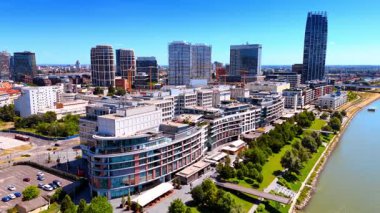 Bratislava, Slovakya - 14 Haziran 2025: Tuna Nehri 'nin Bratislava silueti. Bratislava 'nın ufuk çizgisi modern mimari ve yeşilliği harmanlayarak, güneşli Tuna Nehri kıyısında kentsel yaşamı gözler önüne seriyor..