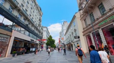 Viyana, Avusturya - 9 Haziran 2025: Viyana 'da alışveriş yapanlar. Turistler, Avusturya 'nın Wien kentindeki canlı bir alışveriş caddesinde dolaşarak mimarinin ve hareketli atmosferin tadını çıkarıyorlar..