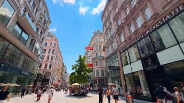 Viyana, Avusturya - 9 Haziran 2025: Viyana 'nın canlı sokakları. Turistler, Wien 'in göbeğindeki işlek caddelerde dolaşıp açık mavi gökyüzünün altındaki dükkanların ve kafelerin tadını çıkarıyorlar..