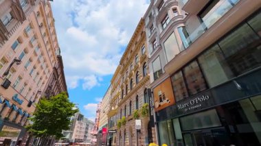 Viyana, Avusturya - 9 Haziran 2025: Modern markaların dükkanlarında büyük sergiler. Avusturya 'nın Viyana kentinin çarpıcı mimarisine alçak açılı bakış açısı.