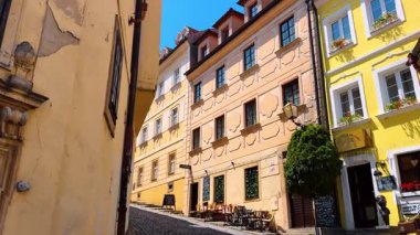 Bratislava, Slovakya, 2 Haziran 2025: Çarpıcı binaların cepheleri boyunca eski asfalt caddenin yanından yürümek. Güneşli bir günde Bratislava, Slovakya 'nın tarihi kısmı.