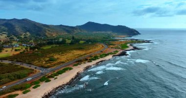 Pasifik Okyanusu kıyısının muhteşem manzarası. Yeşil rıhtımdaki hava perspektifi yeşil dağlarla çevrili..