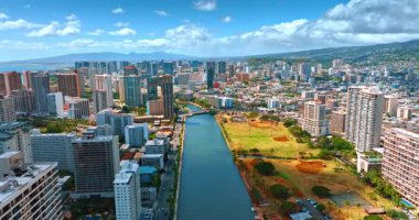 Ala Wai Kanalı üzerinde yükselen Waikiki tatil köyünü ayırıyor. Güneşli bir günde, Honolulu, Hawaii, ABD 'nin engin manzarasını gözler önüne seriyor..