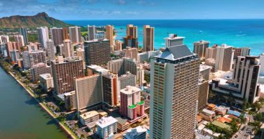 Waikiki tatil köyünün yüksek kentsel manzarası. Arkaplanda güneşin batışının ışığında Diamond Head Krateri. Hava görünümü.