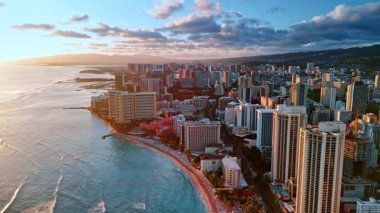 Dar sahilde bir sürü insanın içinde uçmak. Gün batımında Waikiki tatil köyünün havadan görüntüsü. Hawaii, ABD.