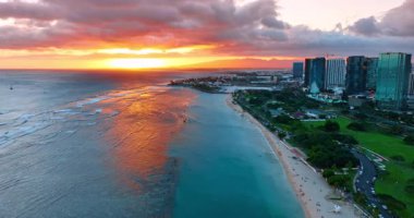 Honolulu kıyısı boyunca Pasifik Okyanusu 'nun su üzerinde uçuyor. Manzaranın üzerinde güneşin batışı. Hava görünümü.