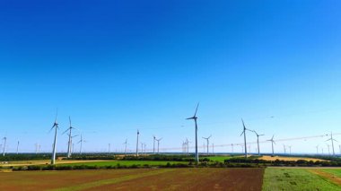 Rüzgar türbinleri güneşli yaz gününde rüzgarda döner. Yeşil enerji konsepti. İnsansız hava aracı görüntüleri.