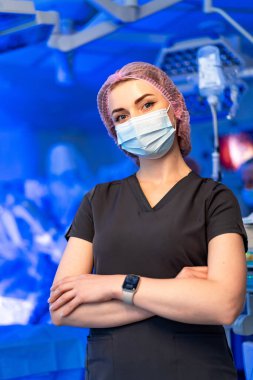 Cerrahi sağlık çalışanı. Bir tıp uzmanı cerrahi bir ortamda kendinden emin bir şekilde duruyor, yaklaşan prosedüre hazır..