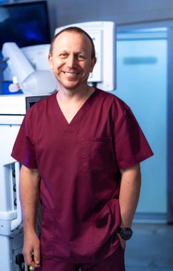 Önlüklü mutlu hemşire. Önlüklü bir sağlık çalışanı hastane ekipmanları arasında güvenle gülümsüyor.