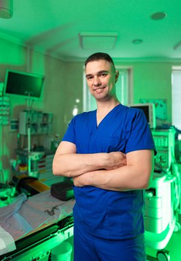 Hastane doktoru. Kollarını kavuşturmuş kendine güvenen bir sağlık çalışanı teknolojik donanımlı modern bir hastane odasında duruyor..