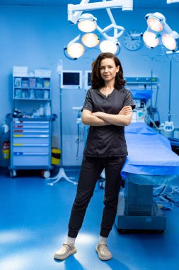 Ameliyathanede cerrah, kendinden emin. Kendine güvenen bir cerrah iyi donanımlı bir ameliyathanede poz verir, bir sonraki işleme hazırdır, profesyonelliği gösterir..