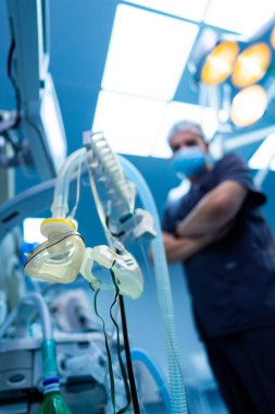 Cerrah ameliyata hazır. Deneyimli bir cerrah, gelişmiş tıbbi ekipman ve parlak ışıklarla çevrili ameliyathanede hazır bekliyor..