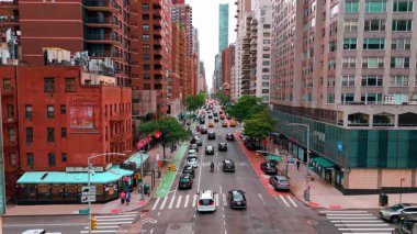 Çok sayıda araba park edilir ve güzel renkli binalar boyunca uzun düz yol boyunca ilerler. Gündüz New York 'un işlek caddesi.