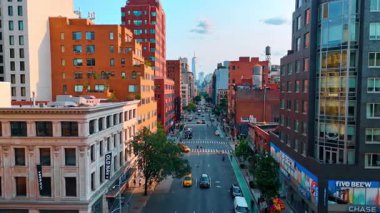 Geniş yol boyunca parlak çeşitli binalar. ABD 'nin New York caddesinde sayısız araba sürüyor..