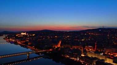 Bratislava, Slovakya 'daki eski kasaba sokak ışıklarını yaktı. Tuna Nehri 'nin yukarısındaki şehrin insansız hava aracı görüntüleri..
